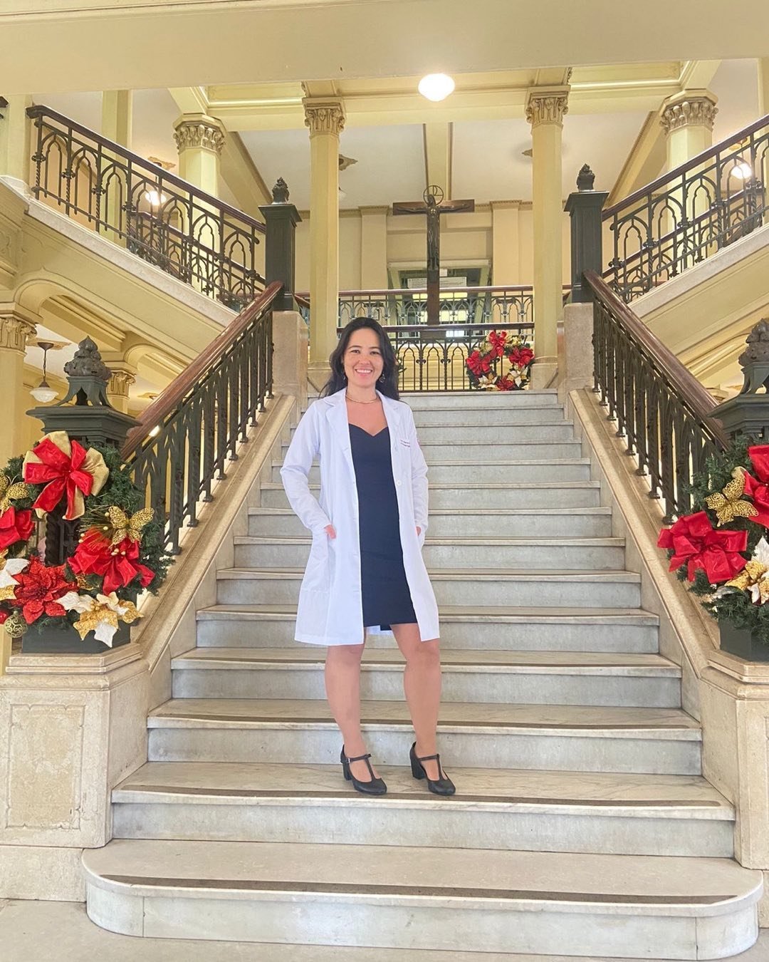Dra. Helen Nakamura de jaleco, em uma escadaria histórica